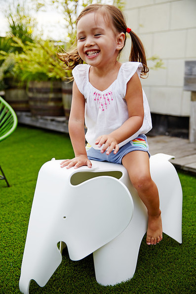 Eames Elephant marca Vitra no jardim com uma criança a sorrir